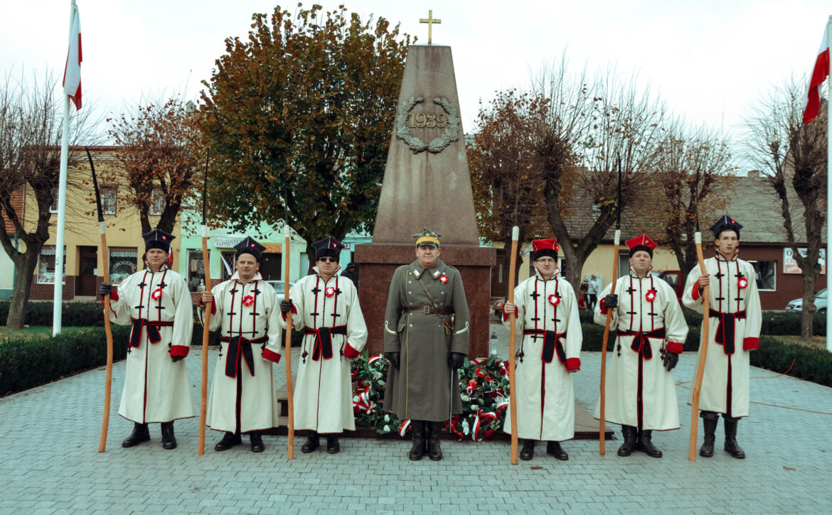 Zdjęcie przedstawia grupę kosynierów na rynku w książu