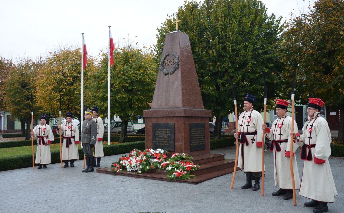 Zdjęcie przedstawia grupę kosynierów na rynku w książu