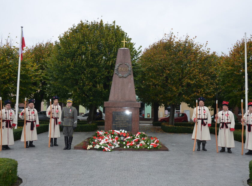 Zdjęcie przedstawia kosynierów przy pomniku na rynku w ksiązu