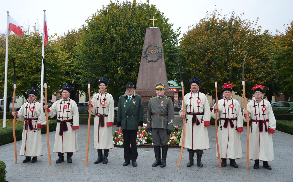 Zdjęcie przedstawia grupę kosynierów na rynku w książu