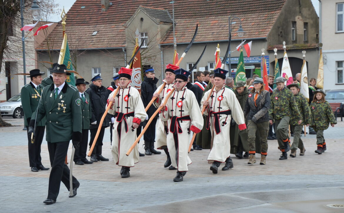 Zdjęcie przedstawia grupę kosynierów na rynku w książu