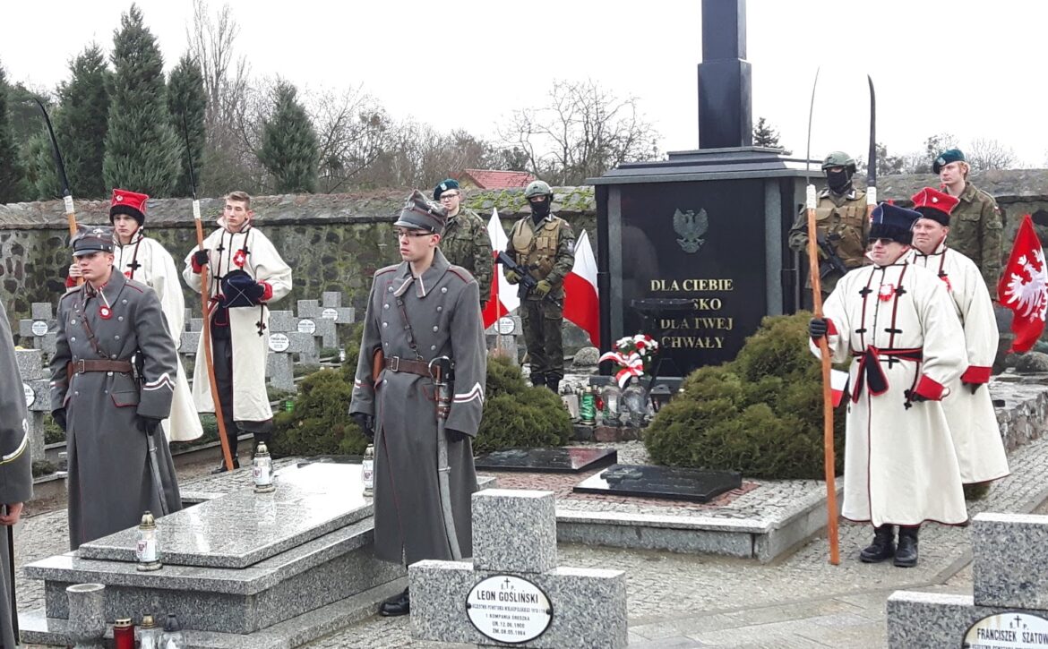 Zdjęcie przedstawia kosynierów na mogiłach