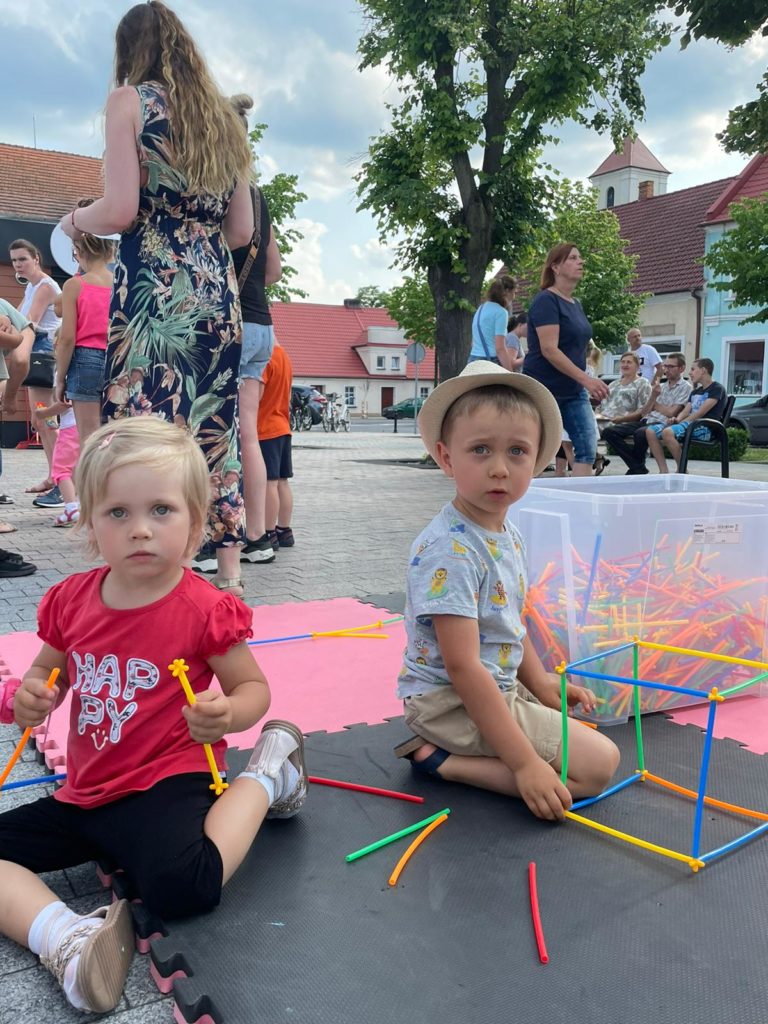Na obrazku dzieci bawią się klockami słomkami
