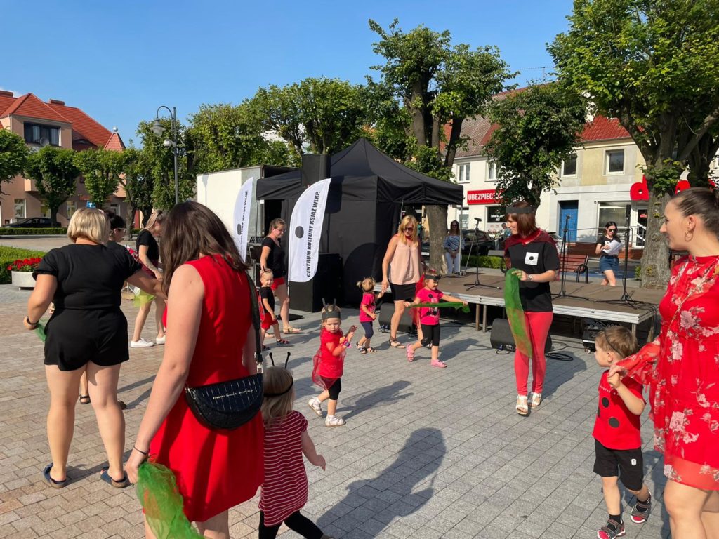Na obrazku kobiety tańczą z dziećmi