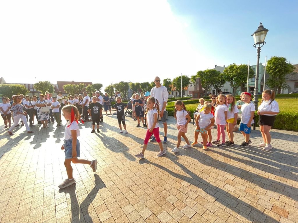 Na obrazku grupa dzieci wchodzi na rynek