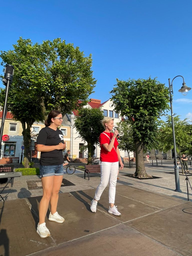 Na obrazku dwie kobiety stoją na scenie