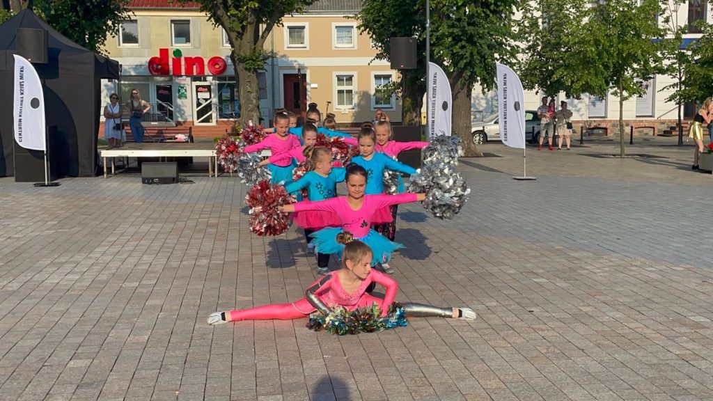 Na obrazku tańczy grupa dziewczynek mażoretek