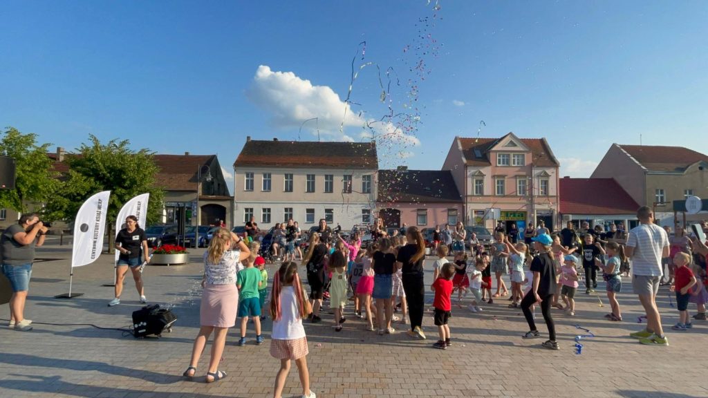Na obrazku grupa dzieci bawi się bańkami mydlanymi