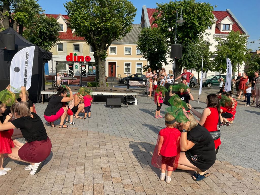 Na obrazku kobiety tańczą z dziećmi