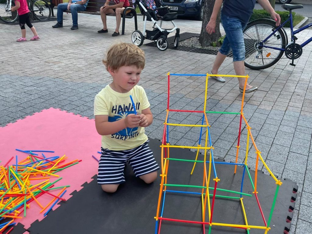 Na obrazku dziecko bawi się klockami słomkami