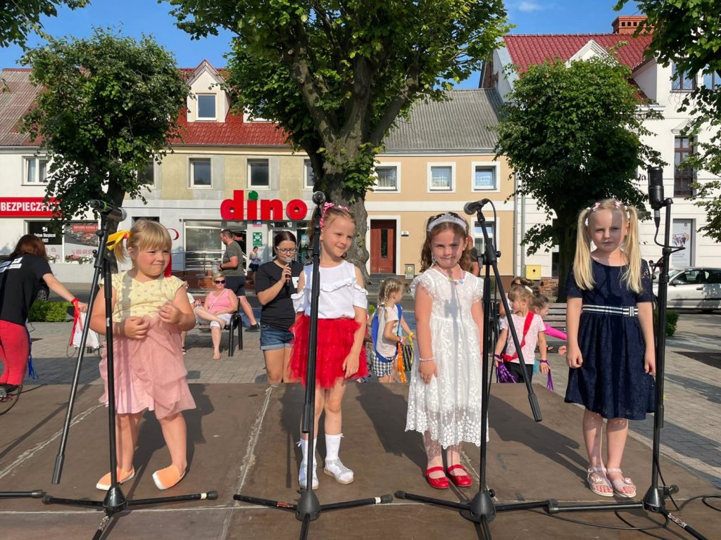 Na obrazku występuje grupa dzieci na scenie