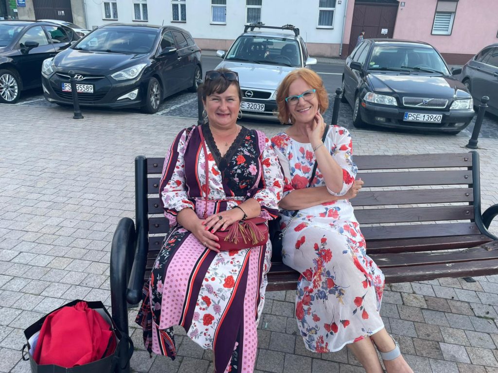 Na obrazku dwie kobiety siedzą na ławce