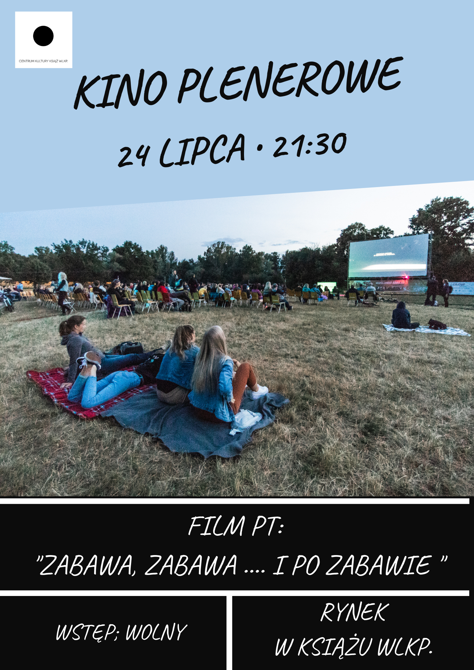 Na obrazku grupa ludzi ogląda kino plenerowe