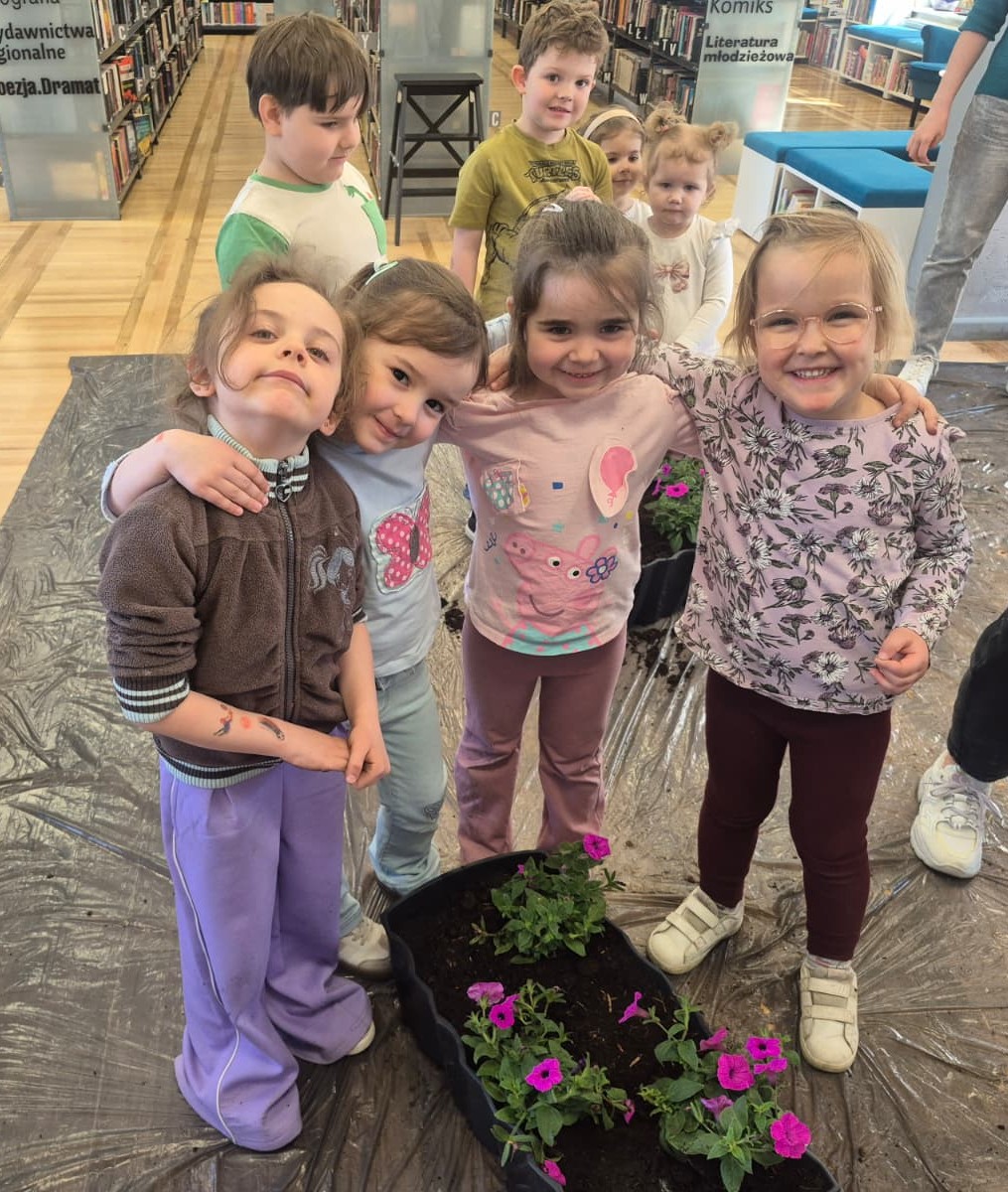 Mali ogrodnicy z "Bajkowego Świata" zasadzili kwiatki przed biblioteką